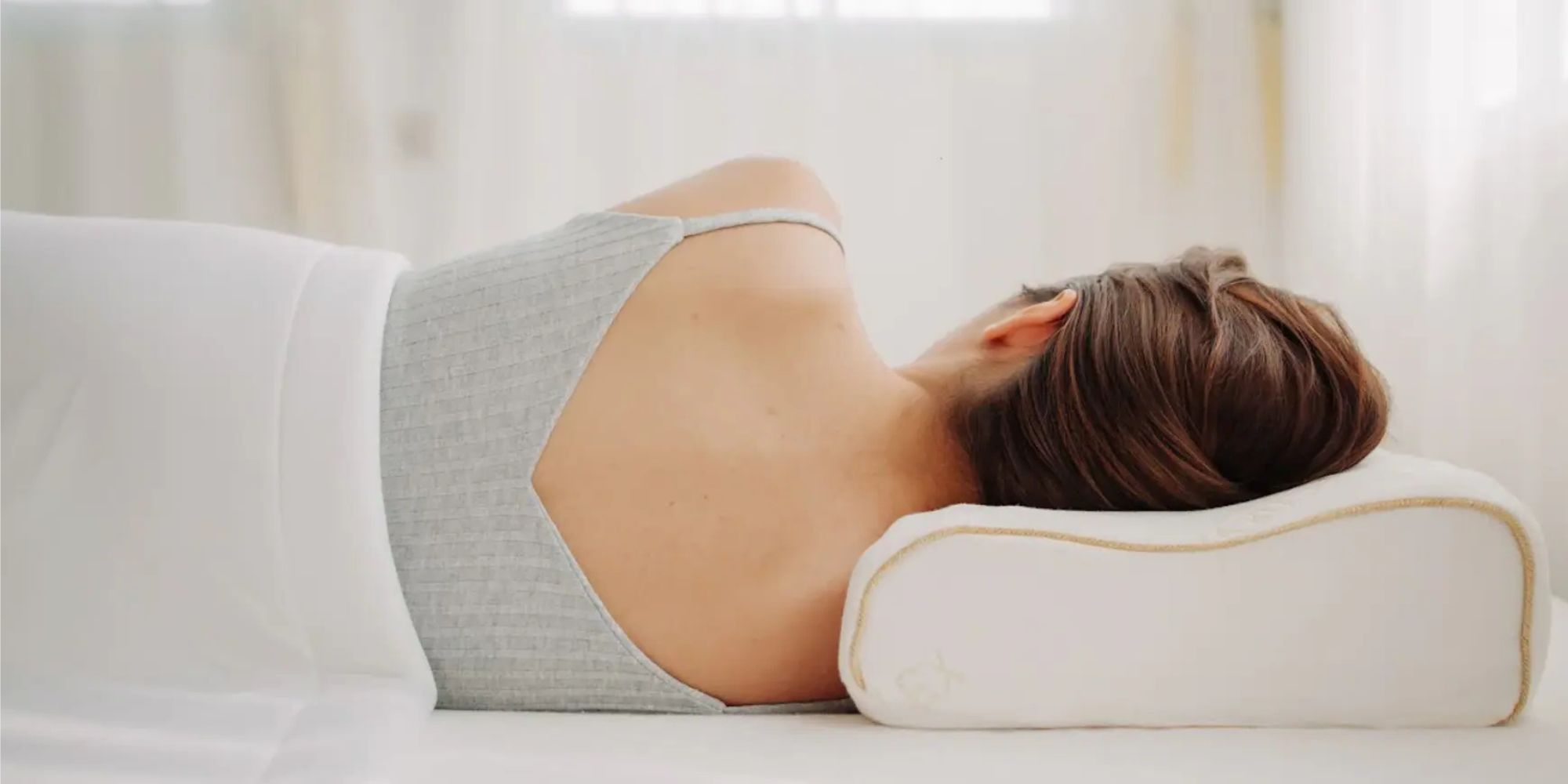 Woman sleeping peacefully on her side, neck fully supported by a contoured natural latex pillow